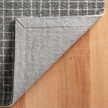 Load image into Gallery viewer, Bottom of the grey rug on hardwood floors