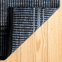 Load image into Gallery viewer, Bottom of the navy rug on a hardwood floor