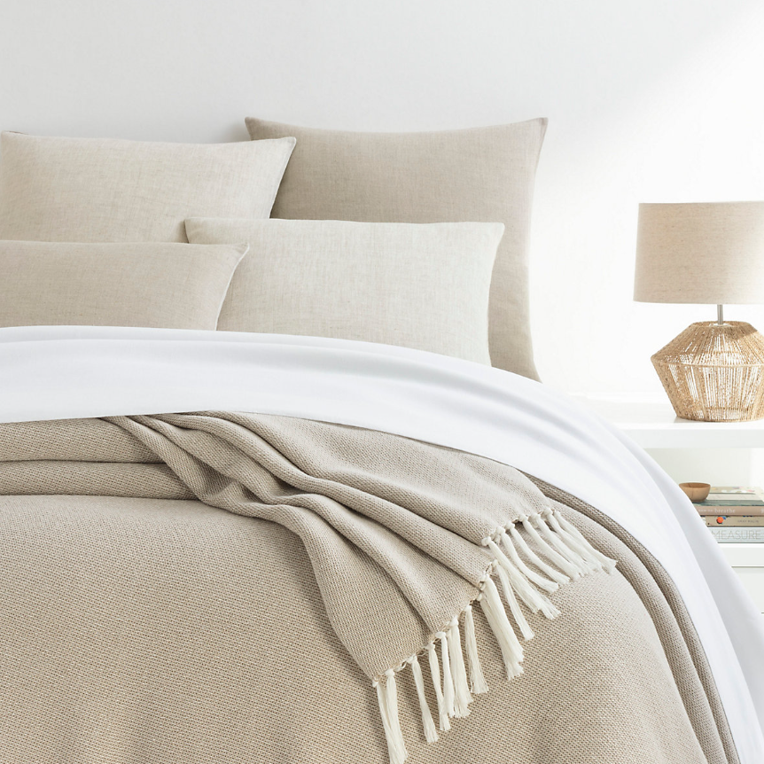 Sand blanket on a white and natural bed setting