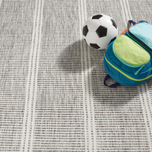 Load image into Gallery viewer, grey rug with a backpack and soccer ball on it
