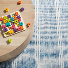 Load image into Gallery viewer, blue rug with a wooden coffee table and a puzzle on it