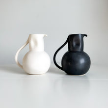 Load image into Gallery viewer, white and black pitcher with a handle sitting on a white shelf