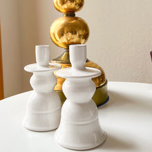 Load image into Gallery viewer, two classic candle holders with a gold lamp in the background