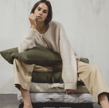 Load image into Gallery viewer, model sitting on four different colored libeco cushions and holding a green pillow