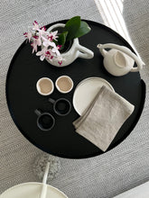 Load image into Gallery viewer, Birdseye view of the white Alex Marhsall teapot, white tumblers, black mugs, dinner plates, and an orchid