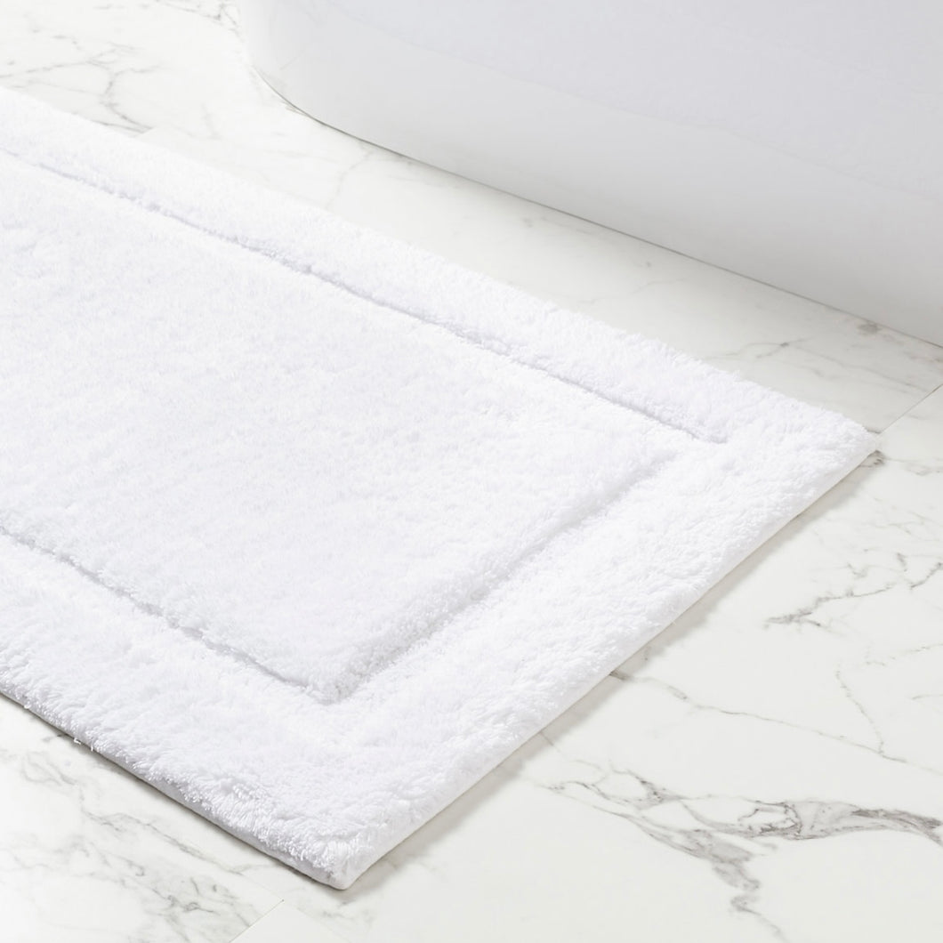 White bath mat on a marble floor