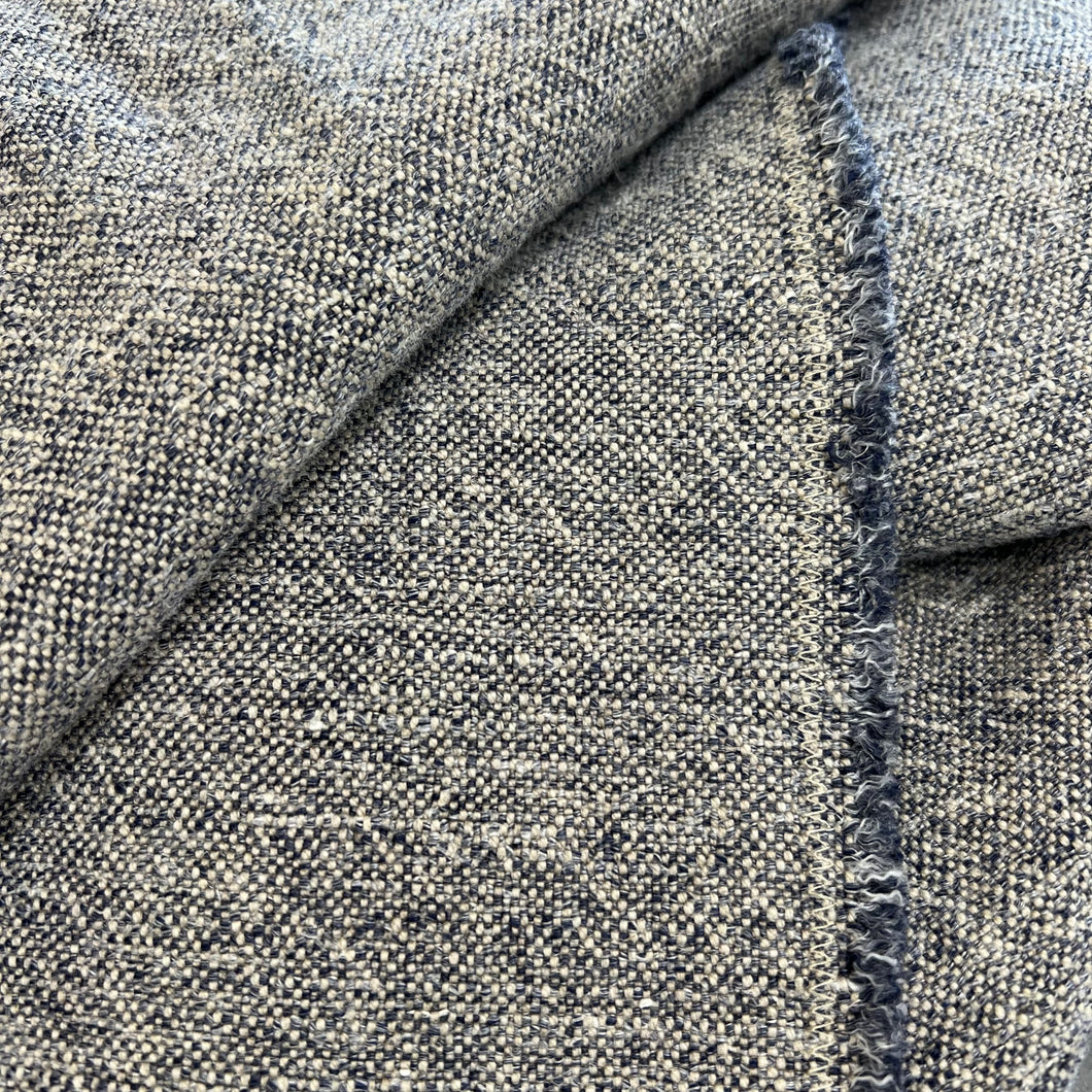 Close up of a blue and grey throw including the freyed seem