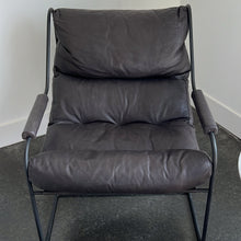 Load image into Gallery viewer, Grey black leather chair on a concrete floor
