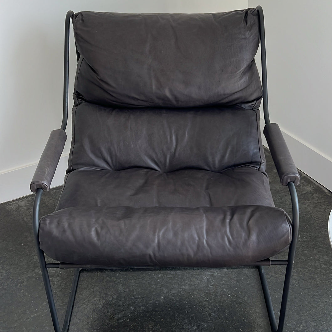 Grey black leather chair on a concrete floor