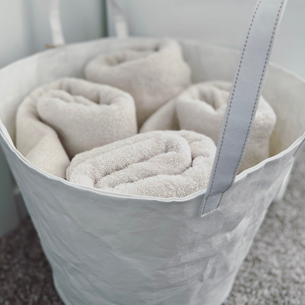 white bucket with four towels rolled up inside of the bucket