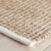 Load image into Gallery viewer, close up edge of the white and wicker rug on a wooden floor 
