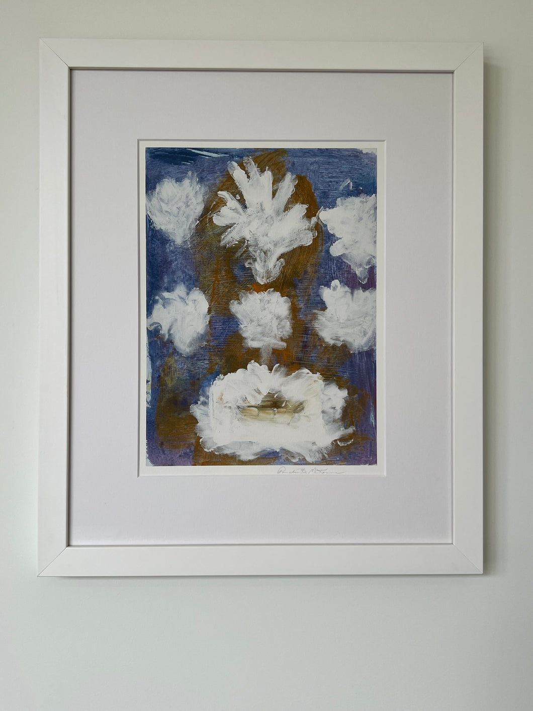 Blue and white floral print with a white mat and white frame hung on a white wall