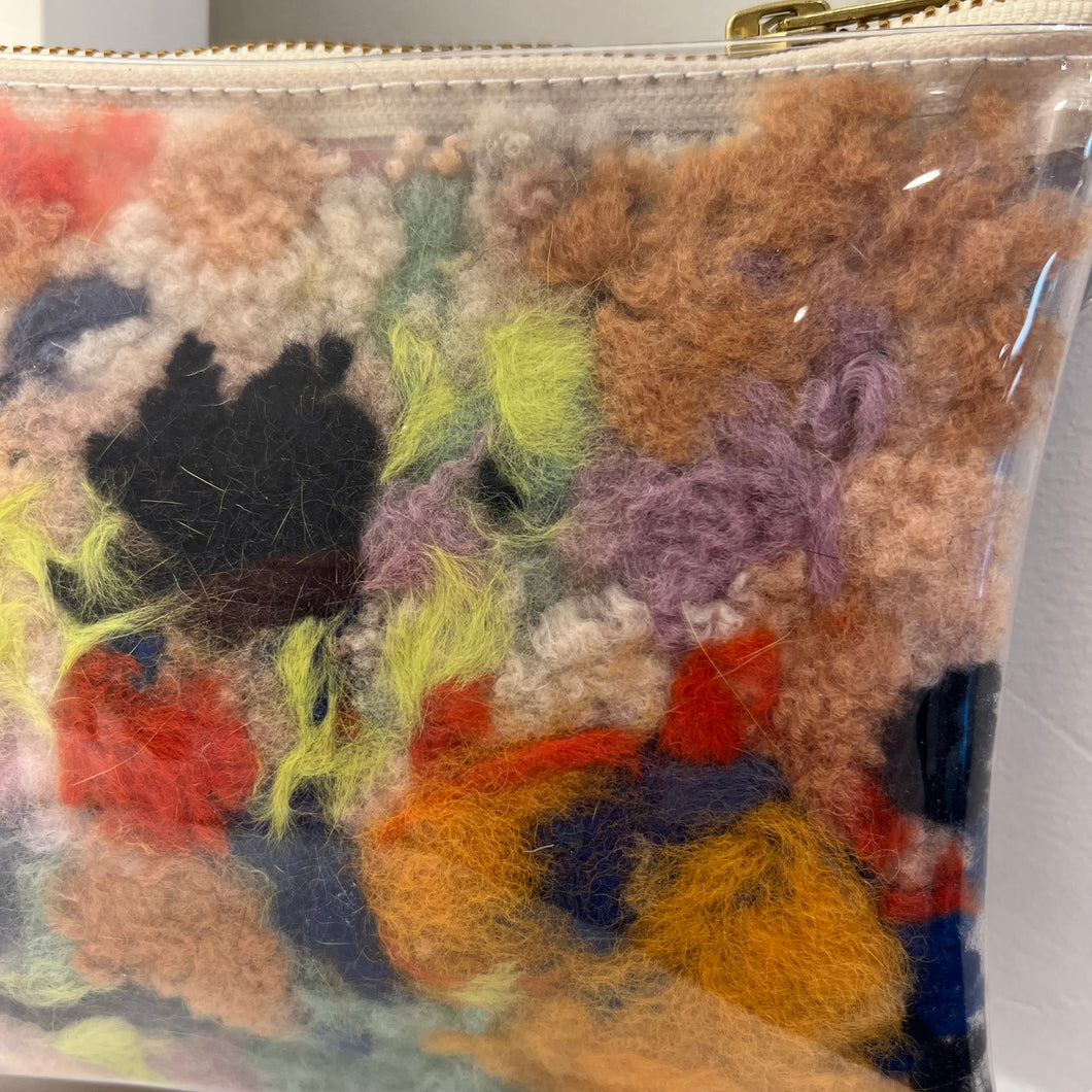 up close photo of the colorful pouch with a brass zipper 