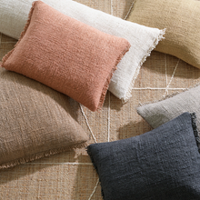 Load image into Gallery viewer, Different sized and colored pillows on a tan rug
