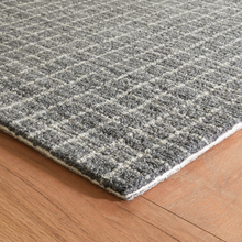 Load image into Gallery viewer, Corner of the grey rug on hardwood floors
