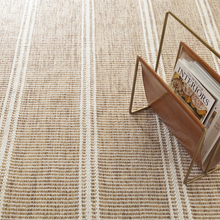 Load image into Gallery viewer, Natural rug with a leather magazine holder with books in it

