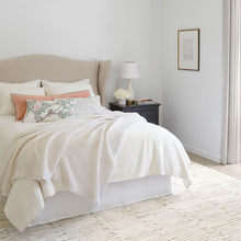Load image into Gallery viewer, Plaster blanket on bed setting in a white bedroom with a bedside table and rug
