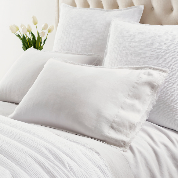 White sheets on a white bed setting