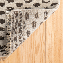 Load image into Gallery viewer, corner of the hugo rug flipped up on hardwood floors
