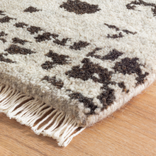 Load image into Gallery viewer, close up corner of the hugo rug on hardwood floors
