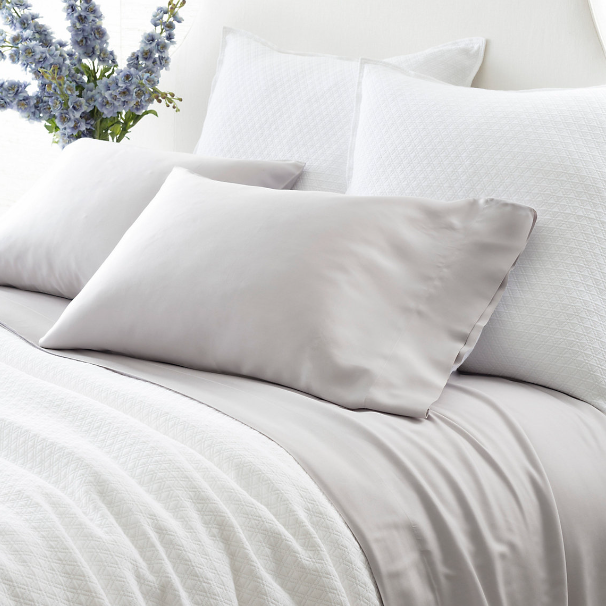 grey pillow cases on a bed setting
