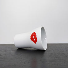 Load image into Gallery viewer, kiss cup laid on its side on a black shelf
