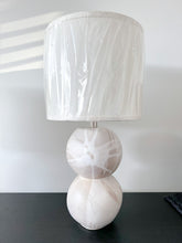 Load image into Gallery viewer, Stone earthy toned table lamp on a black shelf

