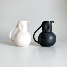 Load image into Gallery viewer, white and black pitcher with a handle sitting on a white shelf
