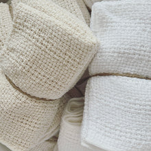 Load image into Gallery viewer, white and oat colored washcloths wrapped in twine

