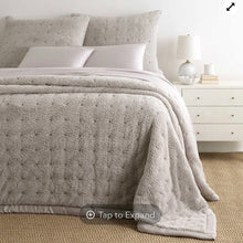 Load image into Gallery viewer, Grey fleece blanket on a bed with a bedside table and lamp on the right
