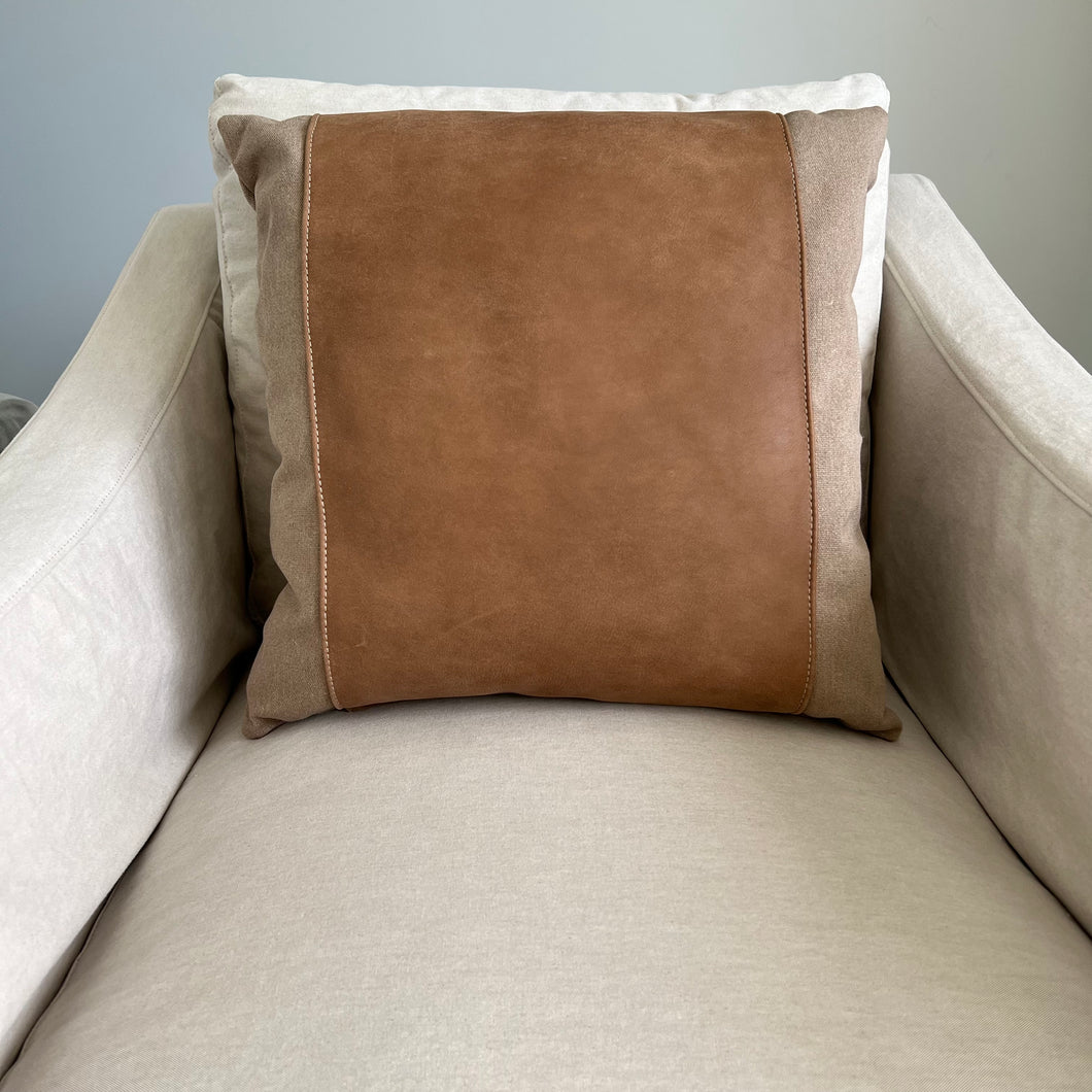 Tan and leather pillow on a tan arm chair