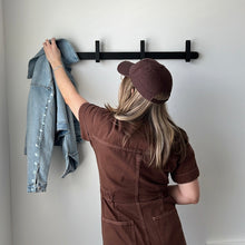 Load image into Gallery viewer, model hanging a jean jacket on the black hoop coat hanger
