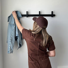 Load image into Gallery viewer, model hanging a jean jacket on the black hoop coat hanger
