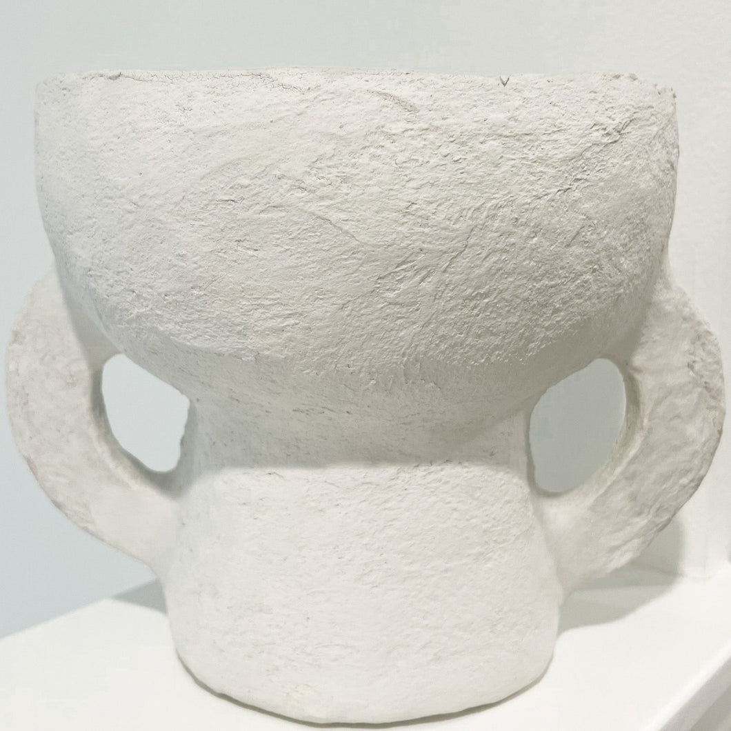 tall two loop paper mache pot on a white shelf