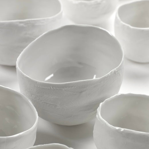 many plaster bowls on a white shelf 