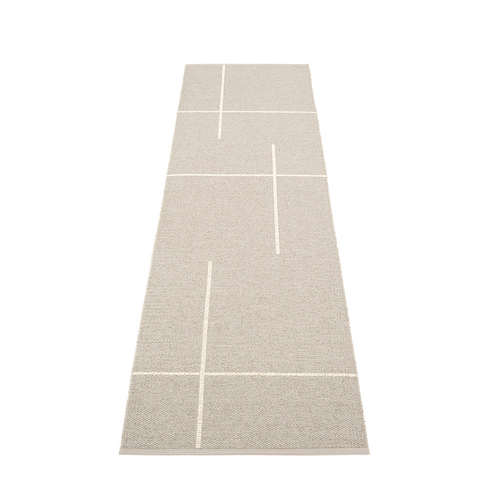 Grey rug with white geometric lines laid on a white floor