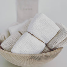 Load image into Gallery viewer, cotton washcloths wrapped in twine in a wooden bowl on a white counter 
