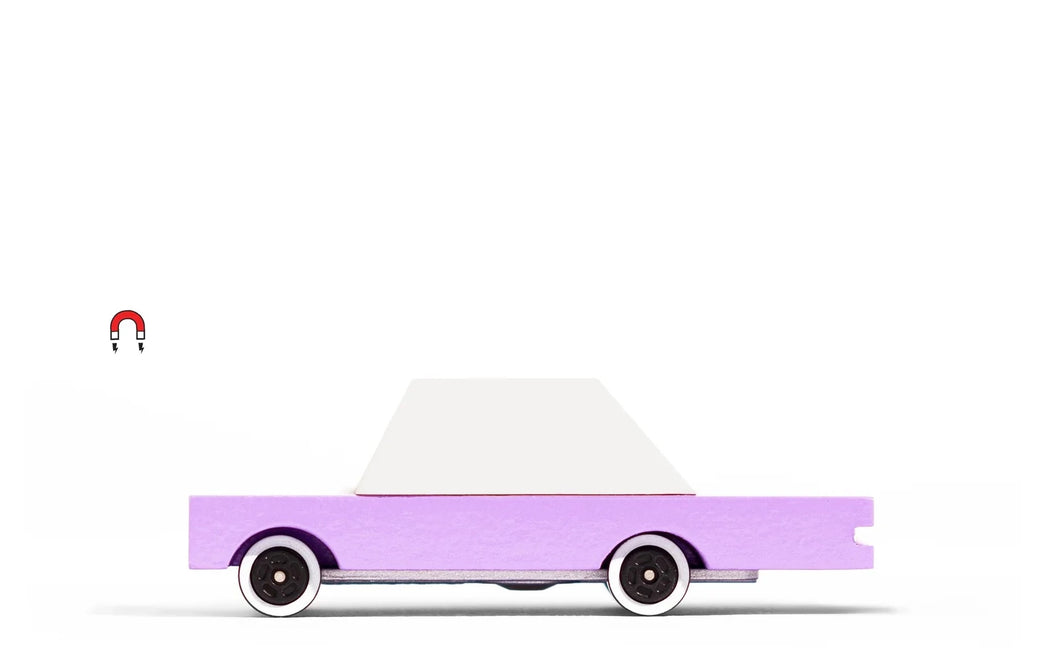 Pink and white wooden toy car by candylab on a white surface