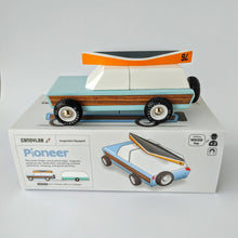 Load image into Gallery viewer, A toy truck on top of the product box with the words Pioneer.  The truck has an orange and gray canoe on top.  THe box has a picture of the toy and the words CandyLab, Imagination equipped, and wood toy.
