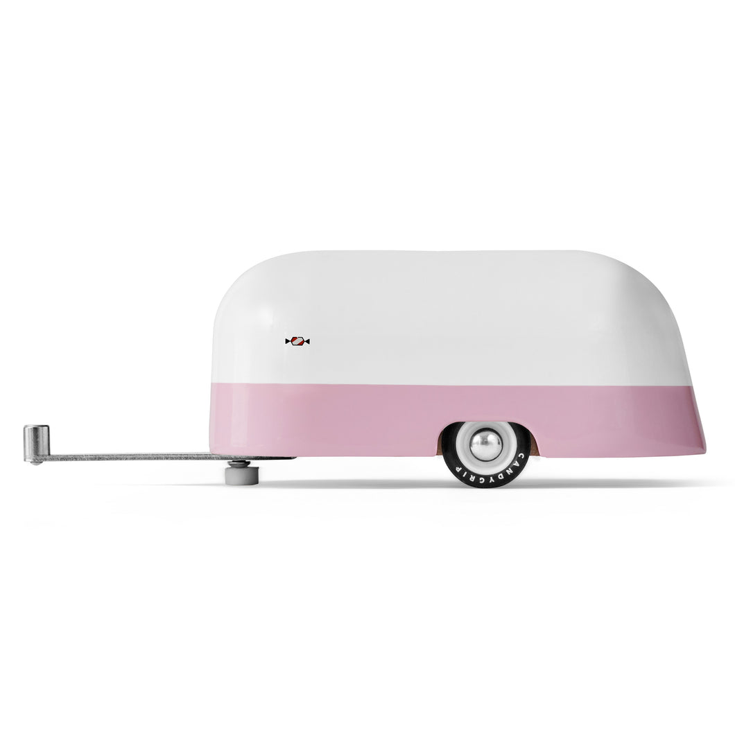 Side of a pink and white painted wooden toy retro camper.