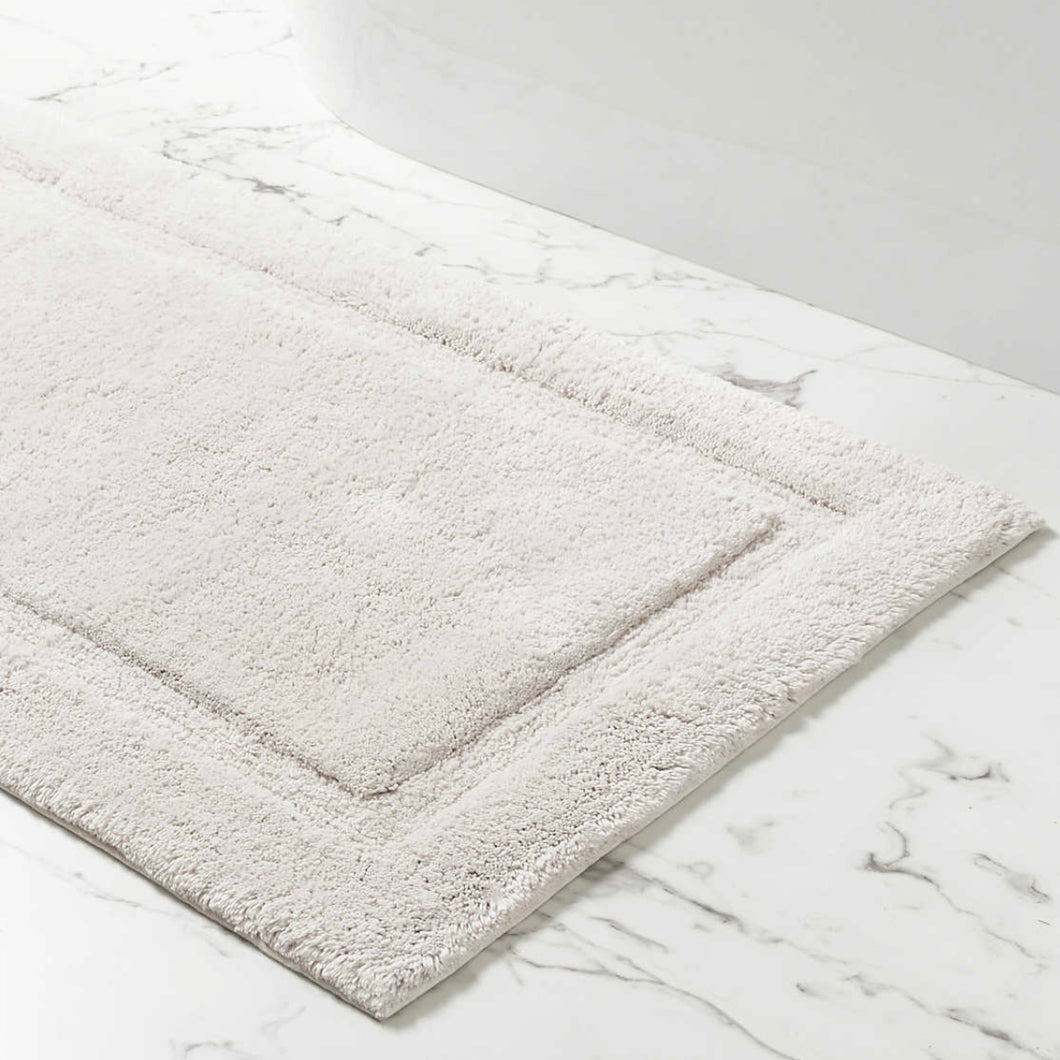 White rectangle bath mat on a marble floor