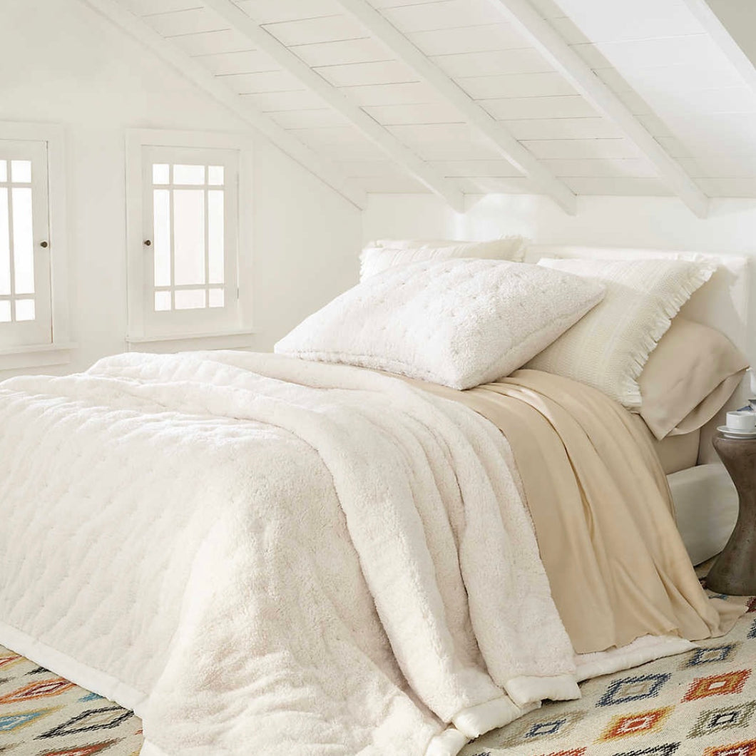White bed with the white fleece blanket on top