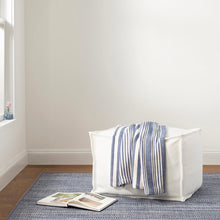 Load image into Gallery viewer, white puff on a blue rug with a blue throw onto of the puff 
