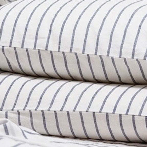 close up of the white and grey linen striped bedding