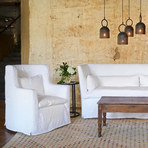 white Havana wing chair next to the sofa with a wooden coffee table in the living room setting