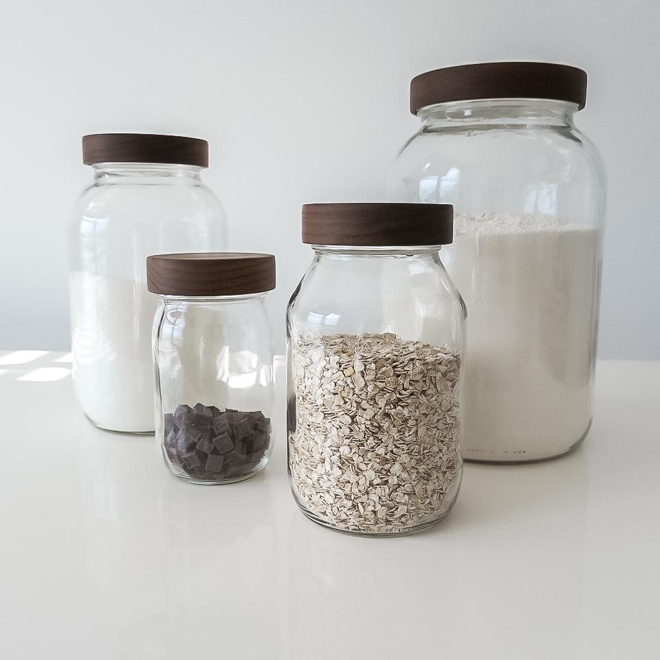 four different sized turnco jars on a white table