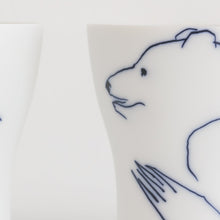 Load image into Gallery viewer, Close up of Hering Berlin brand white porcelain drinking glasses with bears sketched in blue.
