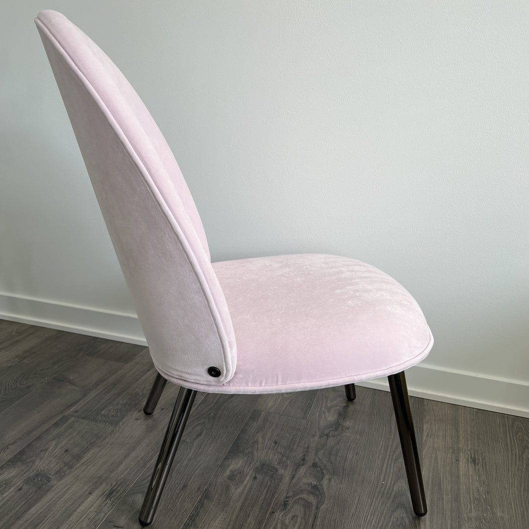 side view of the pink chair on a cement floor
